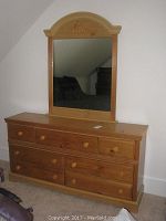 Front view of wooden dresser with attached arched mirror showing full dresser and full mirror.