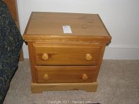 Full view of the wooden nightstand showing its rectangular shape, two drawers, and natural wood finish.