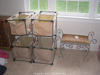Photo of fabric bin storage unit with four beige fabric bins within metal frame next to metal bench.