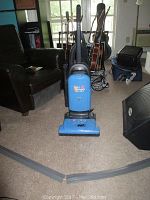 Photo of the Hoover Widepath Tempo upright vacuum cleaner on carpet with attachments visible.