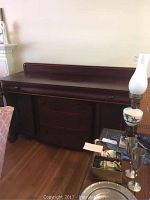 Wide front view of dark mahogany sideboard showing three drawers on top and two cabinet doors below with detailed wooden finish.