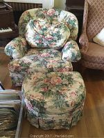 Front view of the large floral upholstered chair and ottoman showing fabric pattern and cushion condition