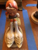Front view of Hummel Goose Girl figurine showing the girl with two geese.