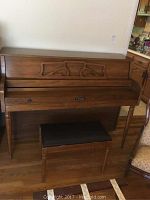 Front view of Kimball upright piano showing main body and carved decorative detail above keyboard.