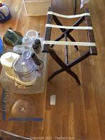 Lot items placed on wooden floor: food processor, canisters, foldable stand and other kitchen accessories