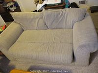 Front and top view of beige/tan upholstered loveseat with a single seat cushion and two large back cushions. Shows wear and soiling.
