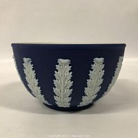 Front view of Wedgewood bowl showing blue jasperware surface with white leaf relief decorations.