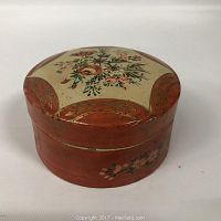 Round painted wood container with floral design on lid and sides.