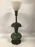 Full view of the lamp showing milk glass shade and painted floral base with metal accents.