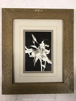 Framed print featuring a black and white still life flower image, in a rustic wood frame.