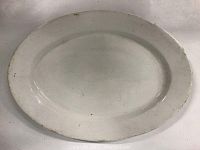 Top view of oval white ironstone platter showing surface wear and size approximately 16.5 x 12 inches.