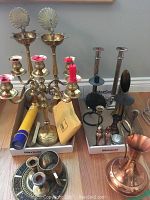 Group of assorted candle holders including brass peacock-back holders, brass candelabra, metal sticks and chambersticks