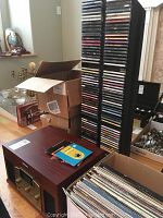 Overview showing stereo console, tall CD rack and box of LP records on table