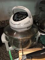 Big Boss halogen oven on countertop with glass bowl, Cuisinart electric knife and green Kishan press visible