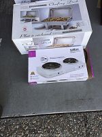 Boxed 9 quart commercial chafing dish and boxed Salton 2-burner portable cooktop placed on concrete floor.