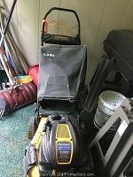 Front side angle view of Cub Cadet self-propelled lawn mower showing engine, black and yellow body, and 2.0 bushel grass collection bag attached.