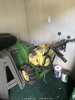 Side view of snow blower showing entire machine and tire chains