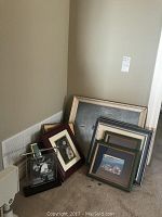 Group shot of five framed artworks leaning against wall