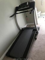 Full view of the Pro-Form 740-CS treadmill against a wall, showing the running surface, handle arms, and base.