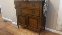 Full view of the dark wood cabinet showing two drawers and bottom cabinet doors.