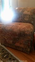 Side chair covered in Parisian style fabric with detailed scenic prints of buildings and flowers, shown from an angle.