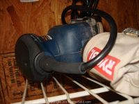 Close-up photo of Ryobi random orbital sander showing dust bag with Ryobi brand visible