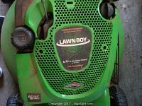 Close-up of Lawn-Boy engine cover with Briggs & Stratton branding and ReadyStart feature, showing green mower body.