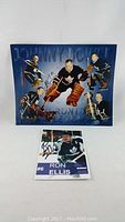 Large blue signed Toronto Maple Leafs photo with multiple players and a smaller signed photo of Ron Ellis in front.