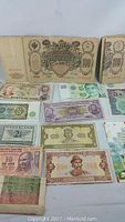 Photo showing various world banknotes including 100 Russian rubles, 10 Indian rupees, Netherlands and Yugoslavian notes.