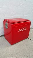 Red metal Coca Cola cooler with closed lid showing latch and handle