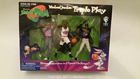 Front of unopened box showing three Michael Jordan Space Jam 'Triple Play' action figures in golf, basketball, and baseball poses.