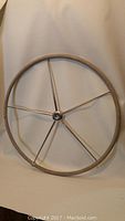 36 inch diameter yacht steering wheel made of wood and metal with 5 metal spokes and a central hub.