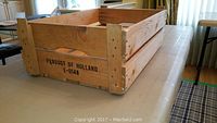 Rectangular wooden crate on table, showing side view and text 'Product of Holland E-0148'