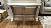 Front view of faux wood veneer console table with whitewashed top and curved legs