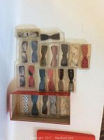 Top view showing most of the vintage clip-on bow ties in their original plastic boxes organized in rows, displaying various colors and patterns.