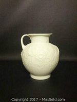 Image of the white porcelain pitcher showing textured embossed floral pattern and curved handle