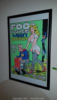 Framed Foo Fighters concert poster featuring nurse and elderly man illustration.