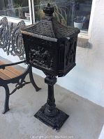 Full profile view of mailbox and pedestal on porch floor