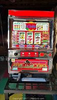 Photo of Aladdin Master Pachislo Slot Machine with colorful front panel, showing slot reels, buttons and payout information with a red header and silver body.