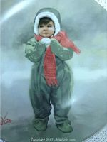 Collector plate showing a child in a green snowsuit with white fur trim and a red scarf, titled 'Winter Angel'