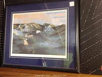 Framed print showing two birds in flight over mountainous terrain, colors include blues, grays, and whites, in a wooden frame with a deep blue matte.
