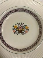 Close-up photo showing design details of one Wedgwood Trentham plate with floral basket and geometric patterned rim.
