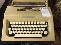 Front view of beige Olivetti Lettera 25 typewriter showing keyboard and case.