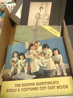 Top-down view of a box containing The Dionne Quintuplets Dolls & Costumes Cut-Out Book and vintage photos.