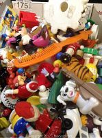 Pile of assorted plastic toys including cartoon characters and small figurines of various colors and shapes