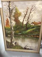 Full view of the framed oil painting showing birch trees, water, hillside, and houses.
