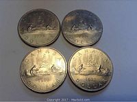 Photo showing all four coins (1979, 1980, 1981, 1982) arranged in a square on a light background, clearly showing the canoe design and year stamps.