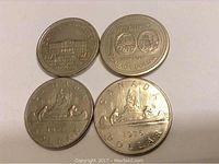 Four silver coloured Canadian dollar coins dated 1973, 1974, 1975, 1976 showing front designs including inscriptions.