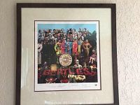 Full view of framed lithograph hanging on textured wall