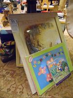 Framed Peter Rabbit wall art titled 'The Tale of Benjamin Bunny' displayed with a small Easter themed book in front.
